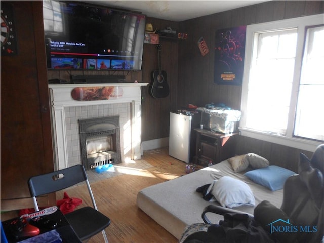 living room featuring hardwood / wood-style floors, a healthy amount of sunlight, and a tiled fireplace