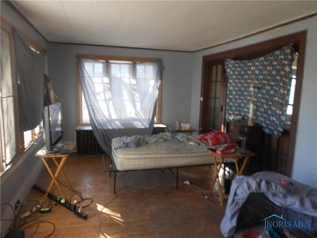 dining area featuring hardwood / wood-style flooring, radiator heating unit, and crown molding