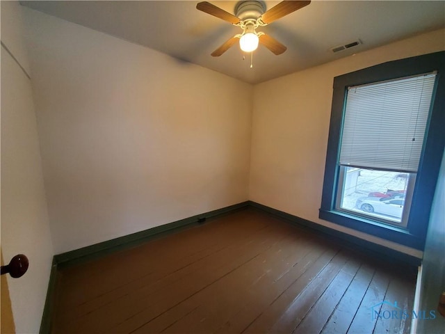 unfurnished room featuring ceiling fan and dark wood-type flooring