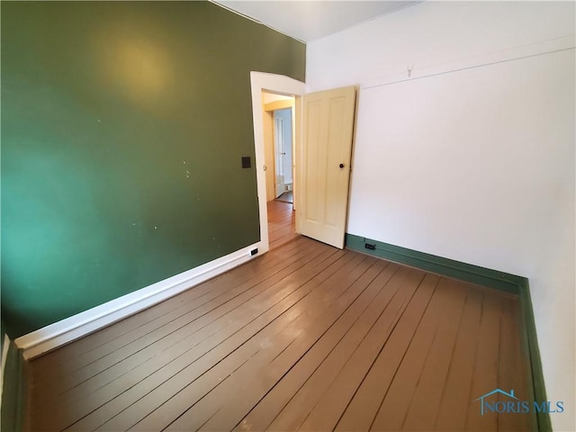 unfurnished room with wood-type flooring