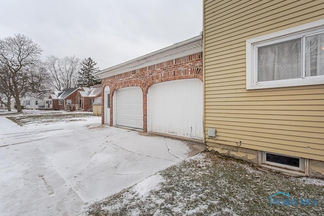 view of snowy exterior featuring a garage