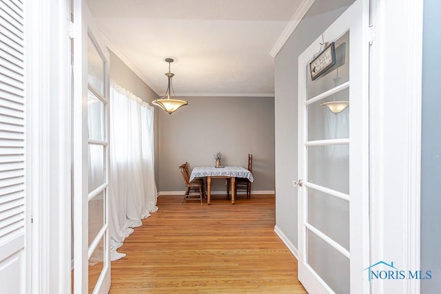 dining area with light wood-type flooring and ornamental molding