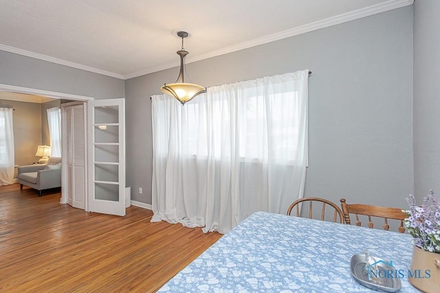 dining room with crown molding and hardwood / wood-style flooring