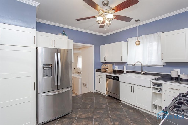 kitchen with washer and dryer, sink, white cabinetry, ornamental molding, and stainless steel appliances