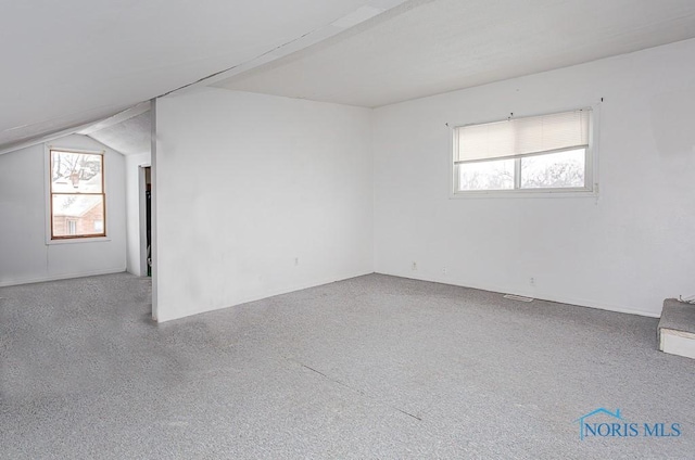 unfurnished room featuring light colored carpet and vaulted ceiling