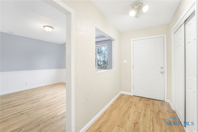 hallway with light hardwood / wood-style floors