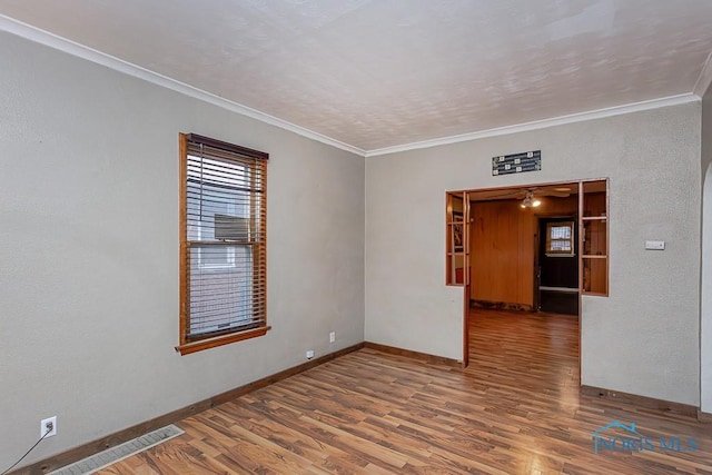 unfurnished room featuring ceiling fan, wood-type flooring, and crown molding