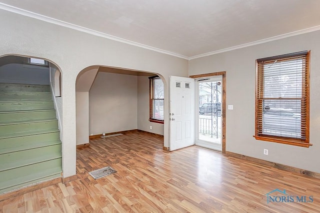 interior space with crown molding, light hardwood / wood-style flooring, and a healthy amount of sunlight