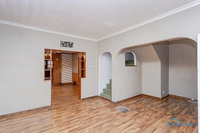 empty room featuring hardwood / wood-style flooring and crown molding