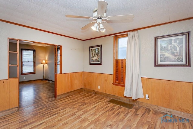 empty room with hardwood / wood-style floors, ceiling fan, and ornamental molding