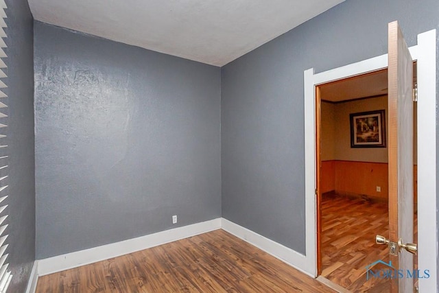 unfurnished room with hardwood / wood-style flooring