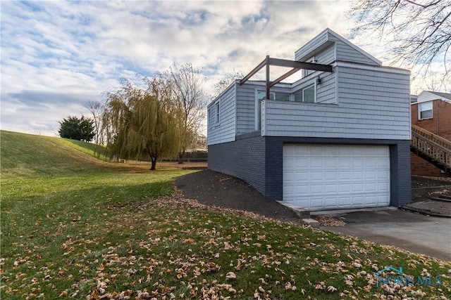 view of side of home with a lawn and a garage