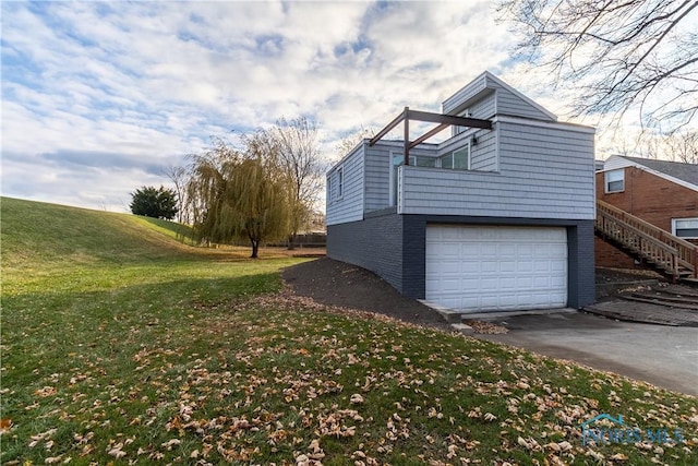 view of side of home featuring a yard and a garage