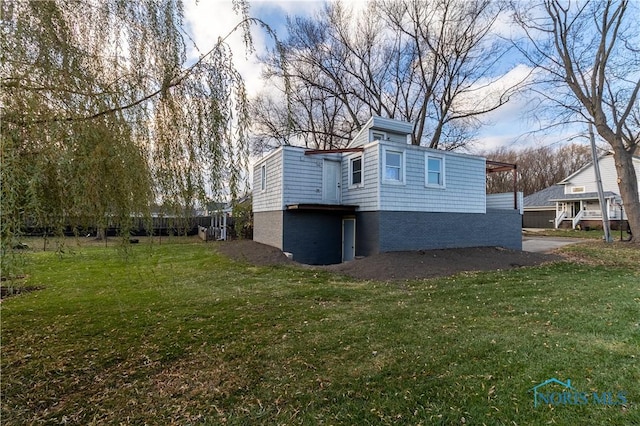 view of side of home with a yard