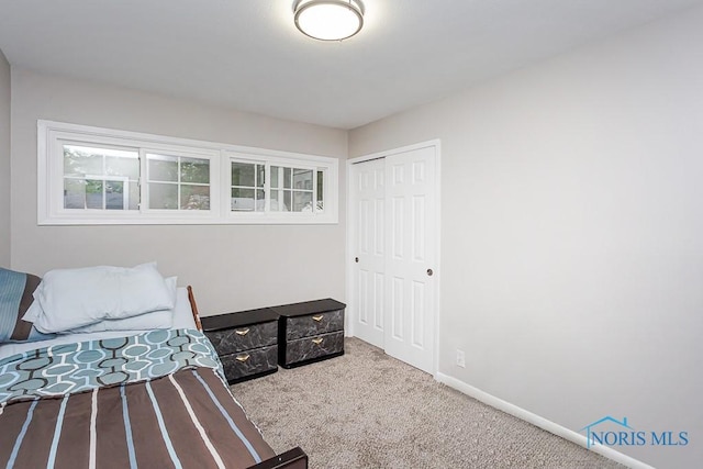 bedroom with a closet and light colored carpet