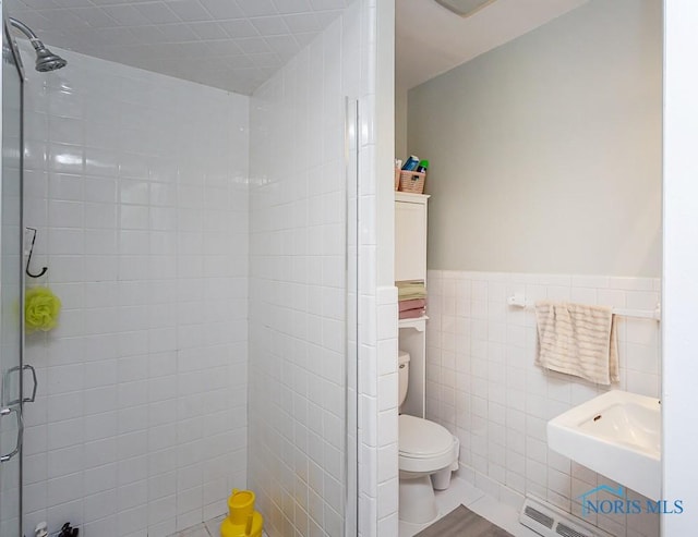 bathroom featuring an enclosed shower, toilet, and tile walls