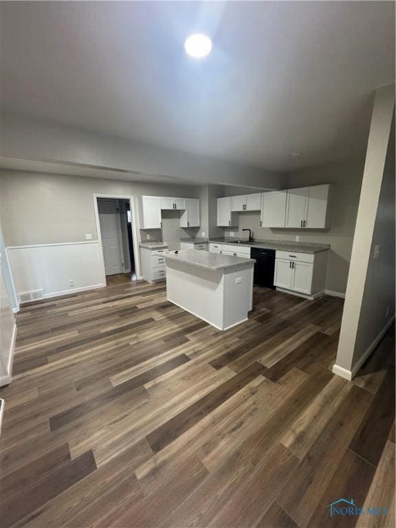 kitchen with white cabinets, dark hardwood / wood-style floors, a kitchen island, and dishwasher