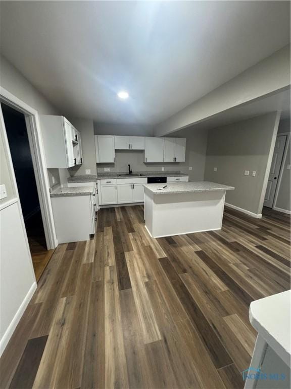 kitchen with a center island, white cabinetry, dark wood-type flooring, and sink