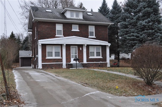 view of front facade featuring a garage, an outbuilding, and a front yard