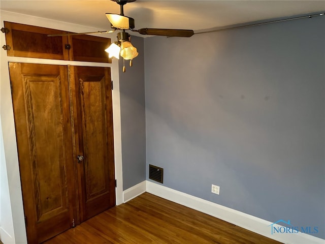 interior space featuring dark hardwood / wood-style flooring, ceiling fan, and crown molding