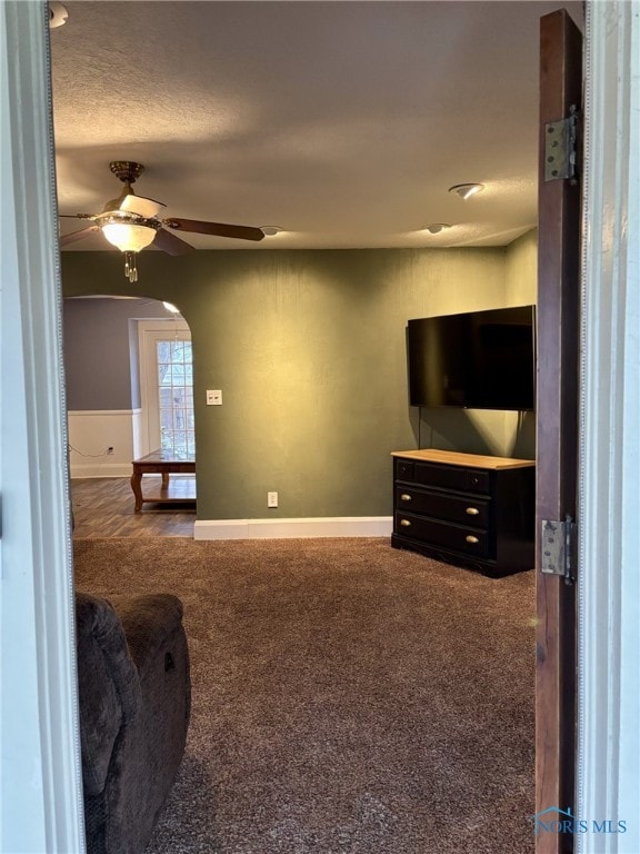 carpeted living room with ceiling fan