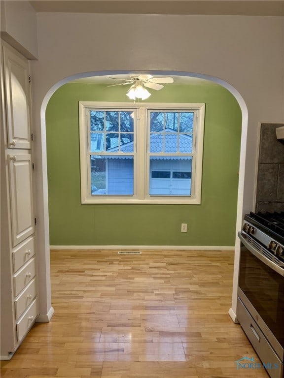 interior space featuring ceiling fan, light hardwood / wood-style floors, and stainless steel gas range