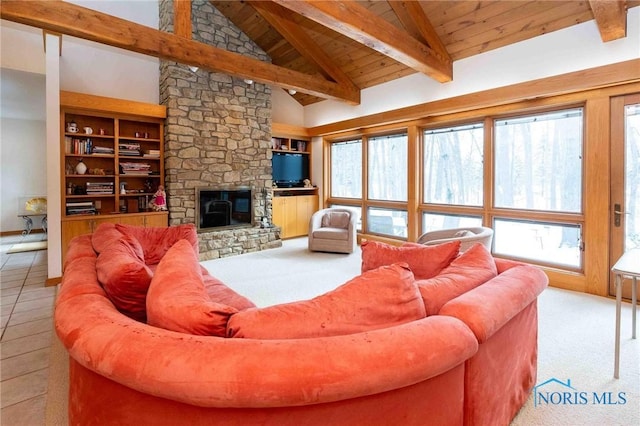 tiled living room with built in shelves, wooden ceiling, a stone fireplace, beamed ceiling, and high vaulted ceiling