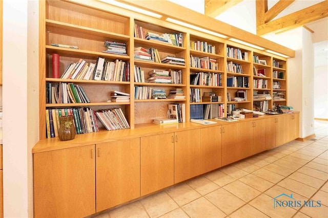 interior space with light tile patterned floors and vaulted ceiling