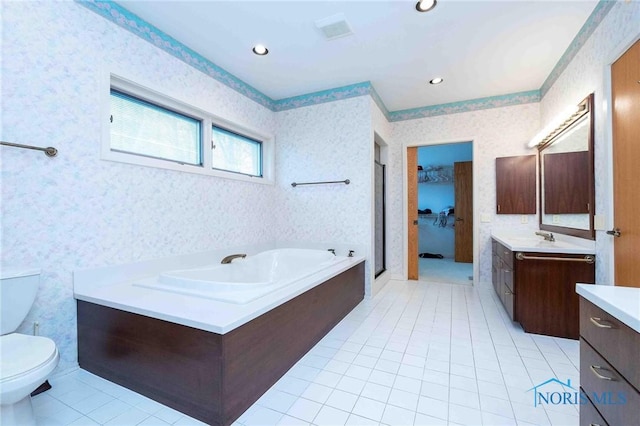 bathroom with a washtub, tile patterned floors, vanity, and toilet