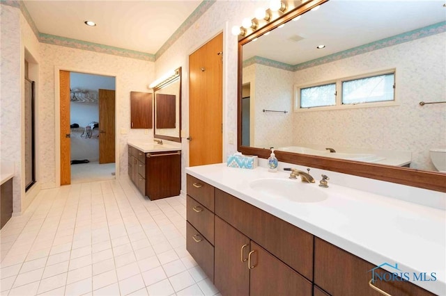 bathroom featuring a washtub, vanity, and tile patterned floors