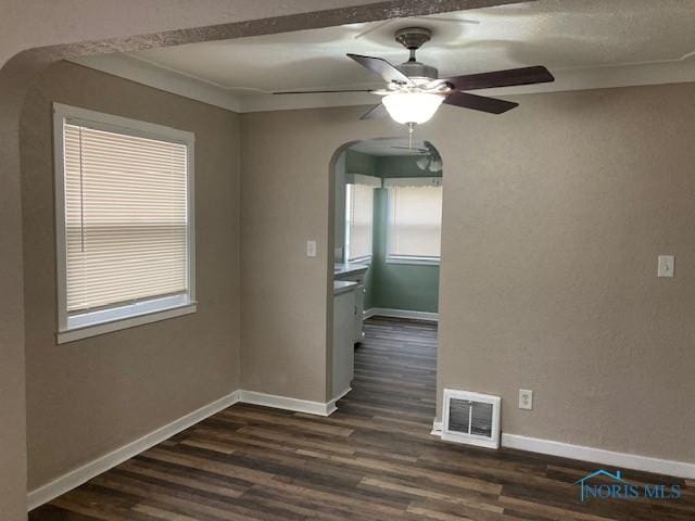 unfurnished dining area featuring dark wood-type flooring, ceiling fan, and ornamental molding