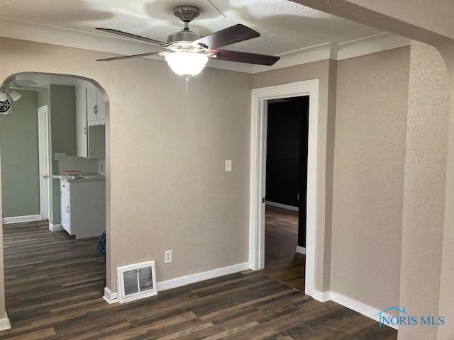 spare room featuring ceiling fan and dark wood-type flooring