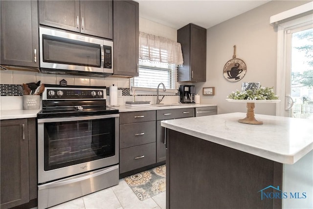 kitchen featuring dark brown cabinetry, sink, and stainless steel appliances