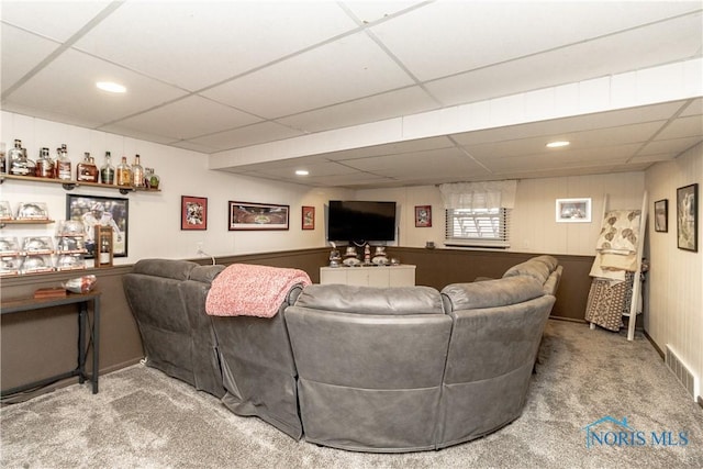 living room with carpet flooring and a paneled ceiling