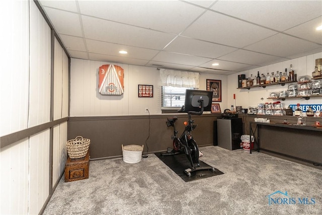 exercise room with bar area, carpet floors, and a paneled ceiling