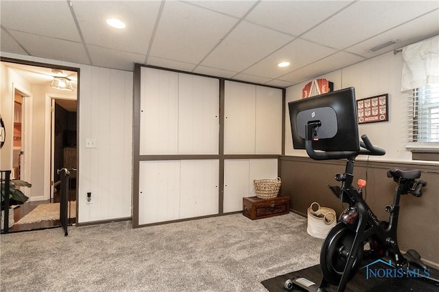 exercise area with light carpet and a paneled ceiling