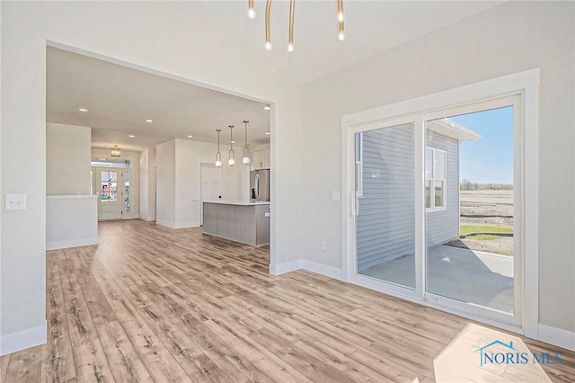 unfurnished living room with french doors and light wood-type flooring