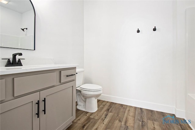 bathroom with hardwood / wood-style floors, vanity, and toilet