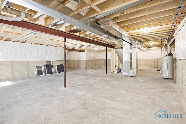 basement featuring gas water heater, brick wall, and heating unit