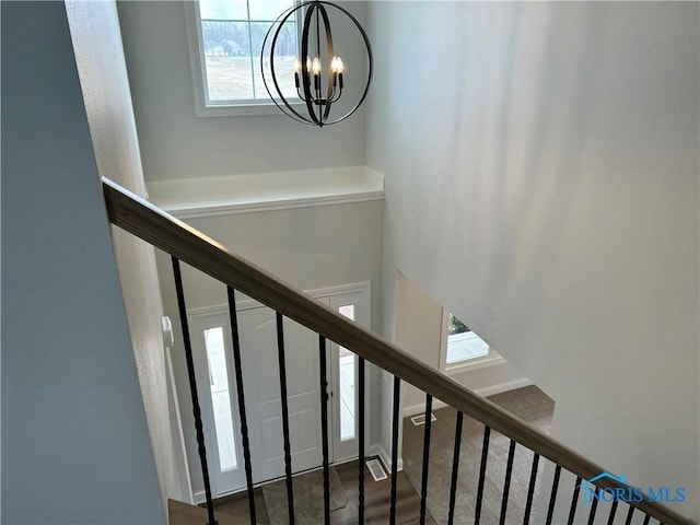 stairway featuring hardwood / wood-style flooring and a chandelier