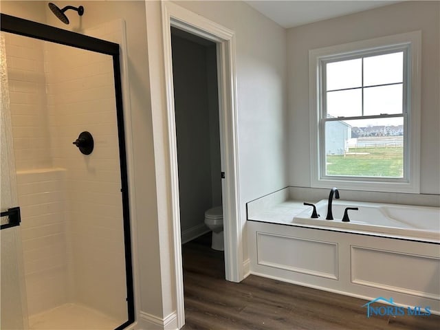 bathroom with wood-type flooring, toilet, independent shower and bath, and a wealth of natural light