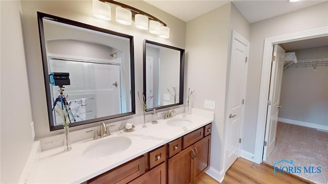 bathroom featuring hardwood / wood-style flooring, walk in shower, and vanity