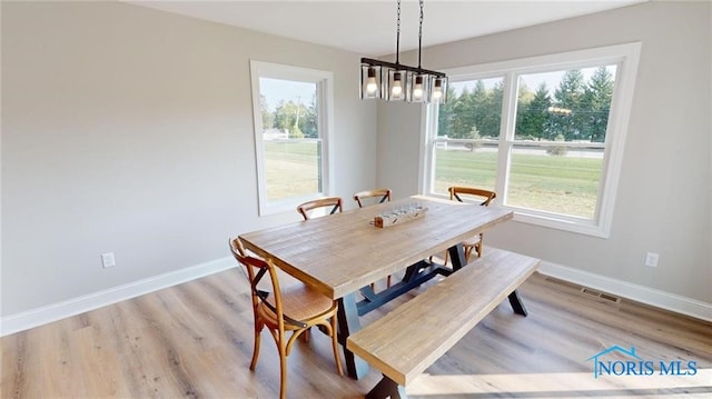 dining area featuring an inviting chandelier and light hardwood / wood-style floors