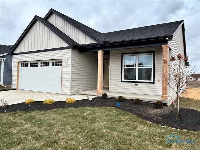 view of front of house with covered porch, a garage, and a front lawn