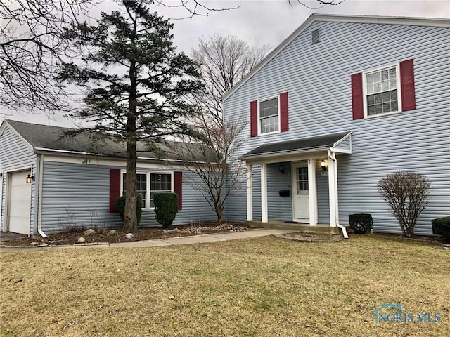 view of property featuring a front yard and a garage