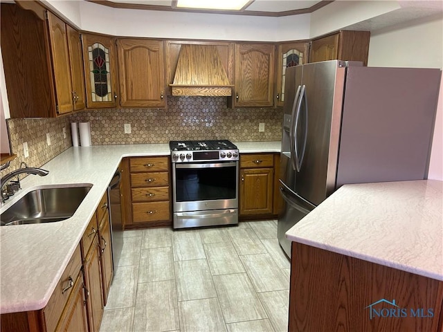 kitchen with sink, decorative backsplash, ornamental molding, custom range hood, and stainless steel appliances