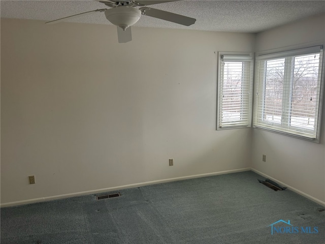 carpeted spare room featuring a textured ceiling and ceiling fan