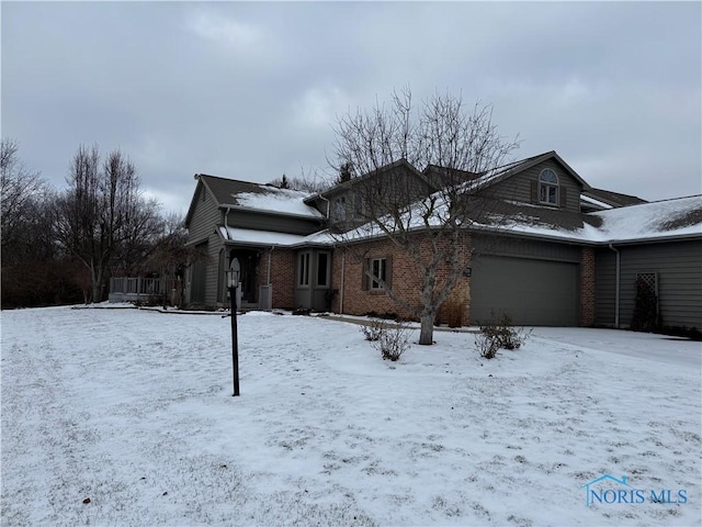 snow covered property featuring a garage