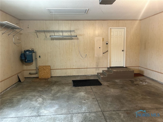 garage featuring electric panel and wooden walls