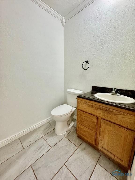 bathroom featuring vanity, toilet, and ornamental molding